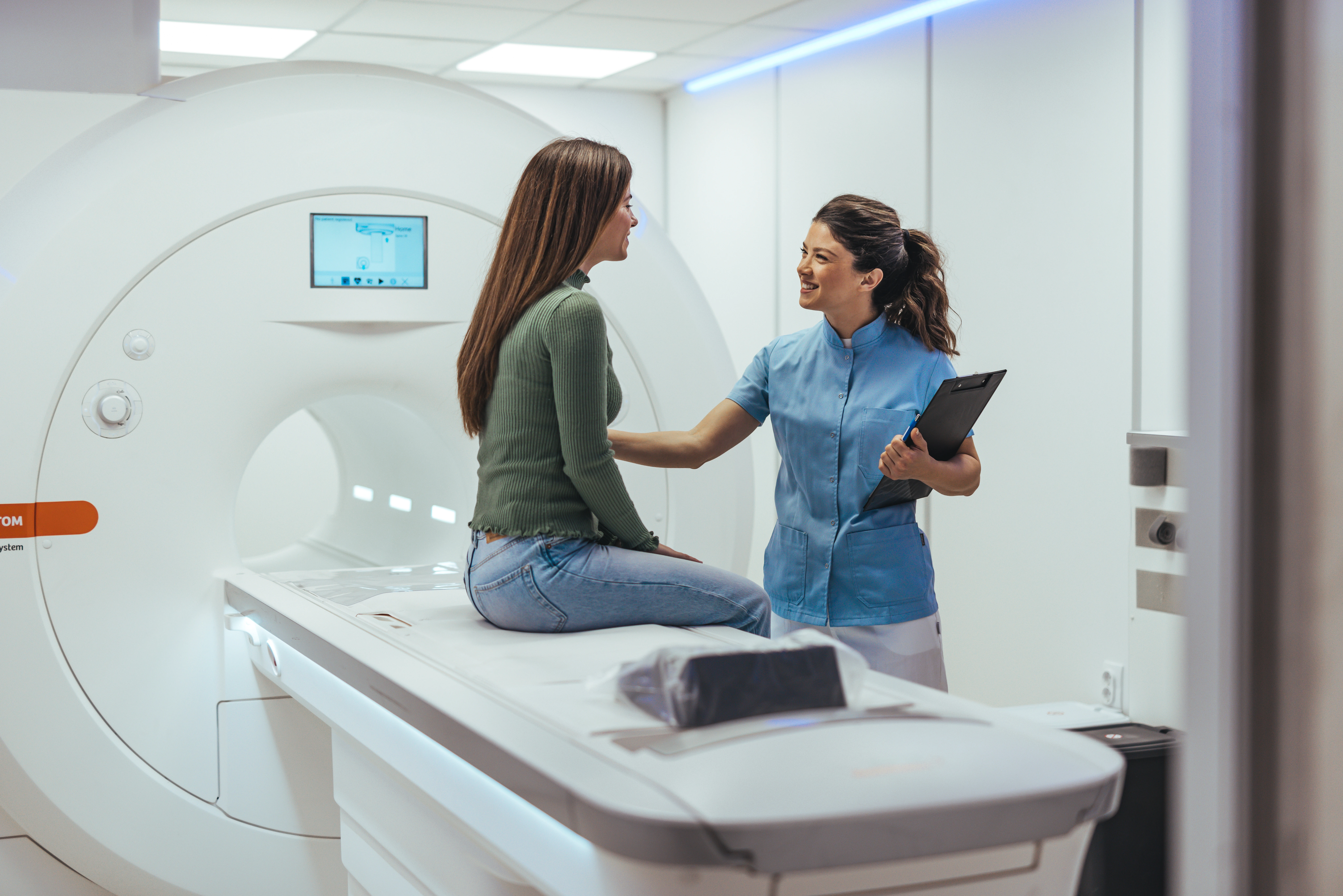Medical personnel assisting a patient as they prepare for a medical scan.