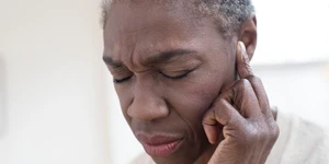 Woman holding ear in pain