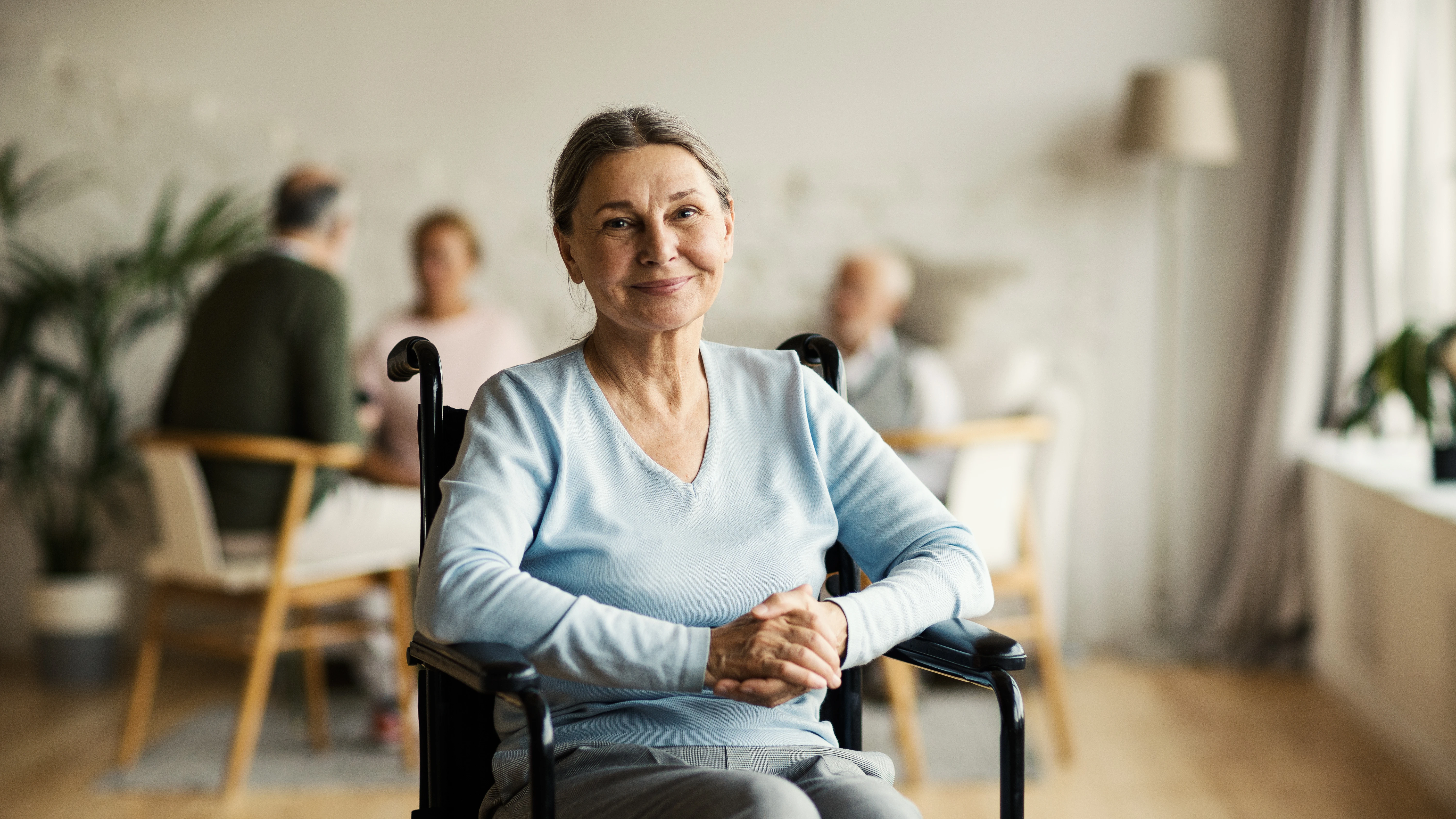 Woman sitting in wheel chair in a medical facility. 