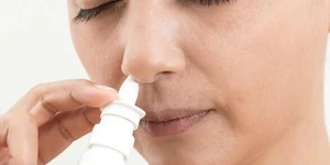 Woman using nasal spray