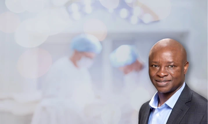 Malachy Asuku with doctors in the background