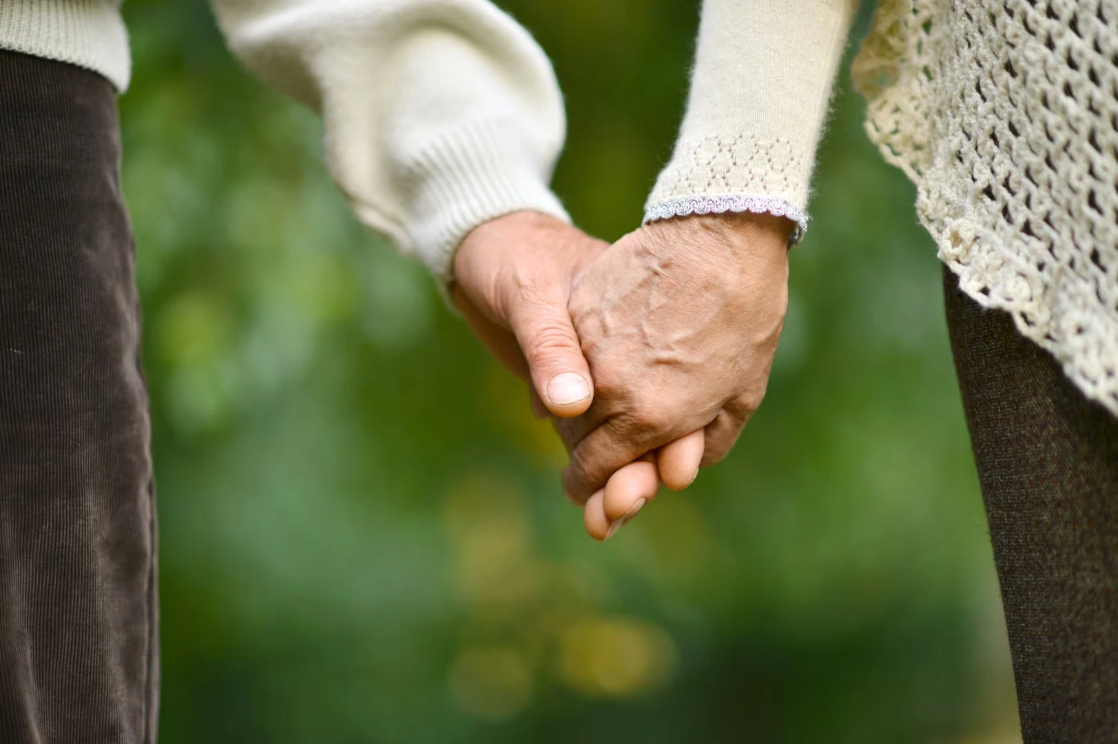 An older couple holding hands.